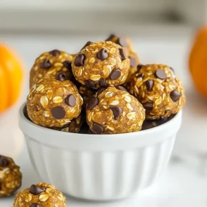 To make Pumpkin Spice Energy Bites, you need the following ingredients: - 1 cup rolled oats - 1/2 cup canned pumpkin puree - 1/4 cup almond butter (or substitute with peanut butter) - 1/4 cup honey or maple syrup - 1 teaspoon pumpkin spice blend - 1/2 teaspoon vanilla extract - 1/4 cup ground flaxseed - 1/4 cup mini chocolate chips (optional, but highly recommended) - Pinch of salt Each ingredient in these bites serves a purpose and boosts health: - Rolled oats: Great for energy and fiber. They keep you full longer. - Pumpkin puree: Packed with vitamins A and C. It adds moisture and flavor. - Almond butter: Provides healthy fats and protein. It helps with heart health. - Honey or maple syrup: Natural sweeteners that give energy and flavor. - Pumpkin spice blend: Adds warmth and comfort. It may help digestion. - Vanilla extract: Enhances flavor. It can also improve mood. - Ground flaxseed: A source of omega-3 fatty acids. It supports heart health. - Mini chocolate chips: They add sweetness. Plus, they make the bites extra fun! - Salt: Balances flavors and enhances sweetness. If you need to swap ingredients, here are some easy options: - Rolled oats: Use quick oats for a different texture. - Almond butter: Peanut butter works well. Sunflower seed butter is a nut-free option. - Honey: Agave syrup can replace honey for a vegan choice. - Pumpkin spice blend: Make your own with cinnamon, nutmeg, and ginger. - Chocolate chips: Try dried fruit or nuts for a healthier twist. These swaps keep the flavor while catering to your needs. Enjoy making these tasty bites! {{ingredient_image_2}} To make pumpkin spice energy bites, start by gathering your ingredients. You need rolled oats, pumpkin puree, almond butter or peanut butter, honey or maple syrup, a pumpkin spice blend, vanilla extract, ground flaxseed, and a pinch of salt. If you like chocolate, have mini chocolate chips ready. This recipe is quick and takes only about 10 minutes to prep. In a large mixing bowl, add the rolled oats, pumpkin puree, almond butter, honey, pumpkin spice blend, vanilla extract, ground flaxseed, and a pinch of salt. Use a spatula or your hands to mix until you form a sticky dough. Make sure everything is well combined; this helps each bite taste amazing. If using, fold in the mini chocolate chips gently. Next, scoop out tablespoon-sized portions of the dough. Roll each portion into compact balls. This makes them easy to eat and helps them keep their shape. Line a baking sheet with parchment paper. Place the rolled energy bites on the sheet, leaving space between each ball. Chill the baking sheet in the refrigerator for at least 30 minutes. This step helps the bites firm up, giving them the right texture. After chilling, transfer the energy bites to an airtight container. This keeps them fresh and ready for snacking. Enjoy your tasty and healthy treats! To make your energy bites just right, focus on the mix. The oats give a chewy base. The pumpkin puree adds moisture. If the mix feels too wet, add a bit more oats or ground flaxseed. This helps them hold their shape. If they feel too dry, a splash of honey or maple syrup can help. You want them sticky but not gooey. Want to boost flavor? Try adding a pinch of nutmeg or cinnamon. These spices work well with pumpkin. You could also mix in some chopped nuts for crunch. If you love chocolate, the mini chocolate chips add a sweet touch. They blend well with the spices. Enjoy experimenting with flavors to find your favorite. You can make these bites ahead of time. Just prepare the mixture and roll them into balls. After that, chill them in the fridge for 30 minutes. Once they are firm, store them in an airtight container. They will stay fresh for up to a week. You can also freeze them for longer storage. Just take out a few when you want a quick, healthy snack! Pro Tips Chill for Better Texture: Allow the energy bites to chill in the refrigerator for at least 30 minutes. This helps them firm up and makes them easier to handle and eat. Mix It Up with Add-Ins: Feel free to customize your energy bites by adding other ingredients like dried fruits, nuts, or seeds for additional flavor and texture. Use Natural Sweeteners: For a healthier option, consider using natural sweeteners like agave nectar or coconut nectar instead of honey or maple syrup. Storage Tips: Store your energy bites in an airtight container in the refrigerator to keep them fresh. They also freeze well for longer storage! {{image_4}} You can switch up the flavors of your energy bites to keep things fun. Try adding dried fruit like cranberries or raisins for a sweet twist. Chopped nuts, like walnuts or pecans, add crunch and healthy fats. Want a chocolatey kick? Use cocoa powder instead of pumpkin spice. You can also swap in a different spice mix, like cinnamon or ginger, for a unique taste. These energy bites are easy to make for different diets. To make them vegan, simply replace honey with maple syrup. For a gluten-free option, confirm that your oats are certified gluten-free. Most other ingredients are naturally gluten-free, so you can enjoy these bites worry-free. If you're nut-free, use sunflower seed butter instead of almond or peanut butter. Pumpkin spice energy bites are great for any time of day. Enjoy them as a quick snack between meals. They also work well as a grab-and-go breakfast. Just pair them with yogurt or fruit for a balanced start. Feeling sweet? Serve them as a dessert. They’re perfect for gatherings, too. Display them in a mason jar or on a plate to impress your guests! To keep your pumpkin spice energy bites fresh, store them in an airtight container. This helps prevent air from drying them out. You can also layer parchment paper between bites. This will stop them from sticking together. Always keep the container in a cool, dry place or in the fridge. Stored in the fridge, these energy bites can last about one week. The cold helps maintain their flavor and texture. If you notice any changes in smell or look, it’s best to toss them. Always check before snacking! You can freeze these energy bites for longer storage. Place them in a single layer on a baking sheet. Freeze for about one hour until they harden. Then, transfer them to a freezer-safe bag or container. They can last up to three months in the freezer. When ready to eat, let them thaw in the fridge overnight. Enjoy your tasty snack whenever you like! Pumpkin spice energy bites are small, no-bake snacks made with wholesome ingredients. They combine rolled oats, pumpkin puree, almond butter, honey, and pumpkin spice. These bites are chewy, tasty, and packed with nutrients. They provide energy and comfort, perfect for any time of the day. You can make these bites healthier by using natural sweeteners. Instead of honey, try mashed banana or unsweetened applesauce. You can also reduce the chocolate chips or omit them altogether. Adding more flaxseed boosts fiber and omega-3 fatty acids, making them even better for you. Yes! If you want to avoid nuts, simply replace almond butter with sunflower seed butter or tahini. Both options work well and still give a creamy texture. Just make sure to check for allergies if you're sharing these bites with others. Absolutely! Pumpkin spice energy bites are a great snack for kids. They are fun to eat and provide energy for play. They also have a sweet taste that kids love. Just be mindful of any nut allergies when serving them. You can enjoy these bites straight from the fridge as a quick snack. They also make a great addition to lunchboxes. For a treat, pair them with a warm drink, like apple cider or hot chocolate. They’re versatile and perfect for any occasion! This article covered everything you need to know about pumpkin spice energy bites. We explored the key ingredients, their benefits, and tasty alternatives. I shared easy step-by-step instructions to prepare these bites, plus tips for the perfect texture and flavor. We also discussed variations for dietary needs and how to store them properly. Now you can enjoy these delicious snacks anytime. Get creative with flavors or share them with friends. Whether for breakfast or a treat, these bites are sure to please. Enjoy making them!